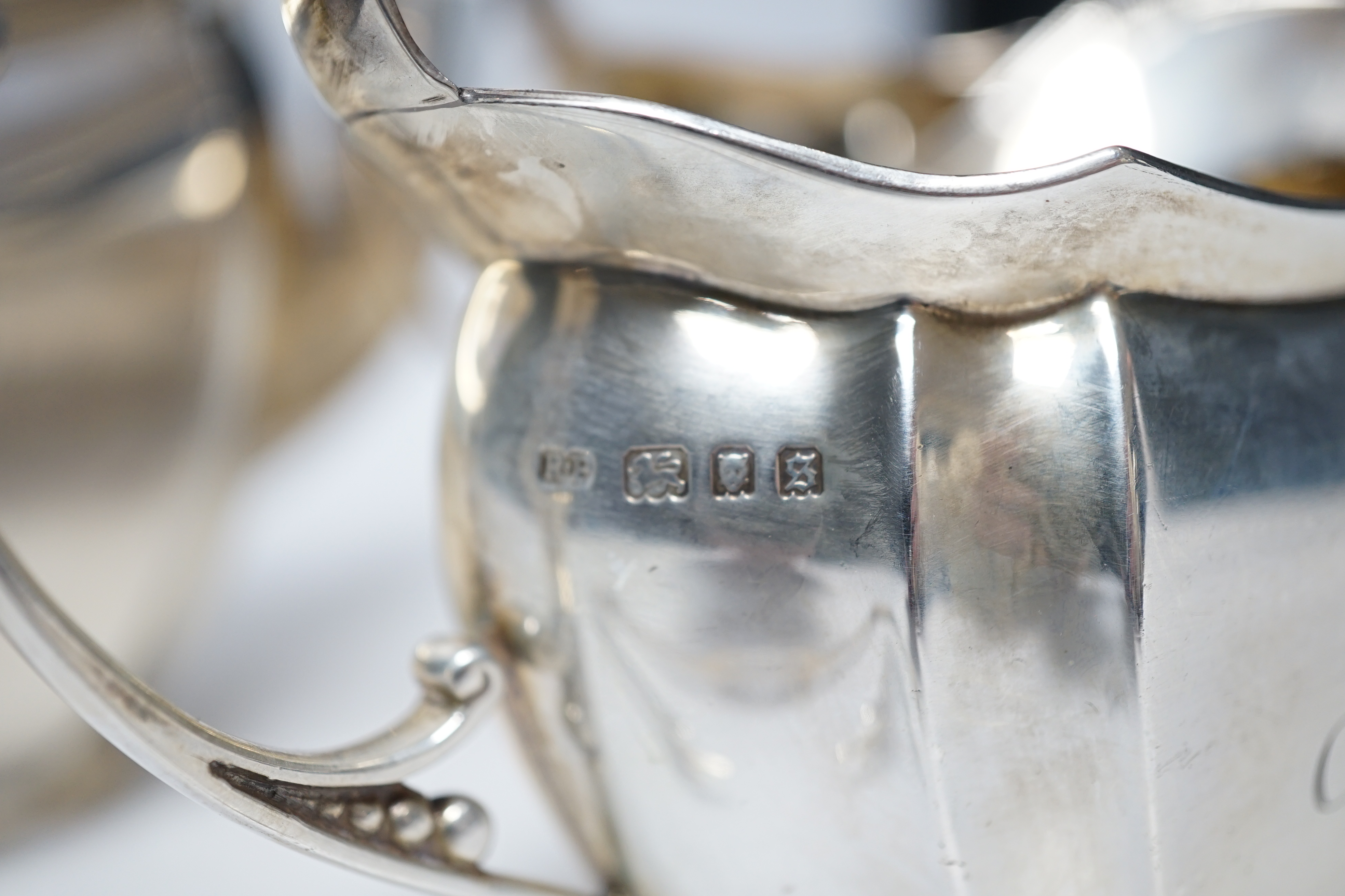 A George V three piece silver tea set by Robert Pringle & Sons, London, 1933, with engraved inscription, together with a pair of associated silver sugar tongs, gross weight 40.7oz.